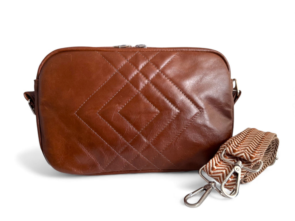 Brown leather Catalina crossbody bag with a strap on a white background