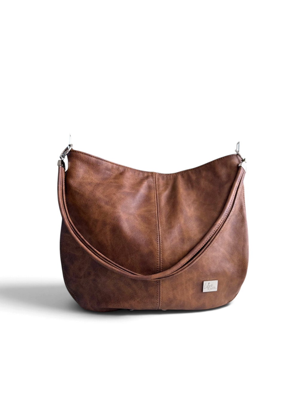 A brown leather hobo shoulder bag with a twin strand strap and a small silver brand plaque on the front, photographed on a clean white background.