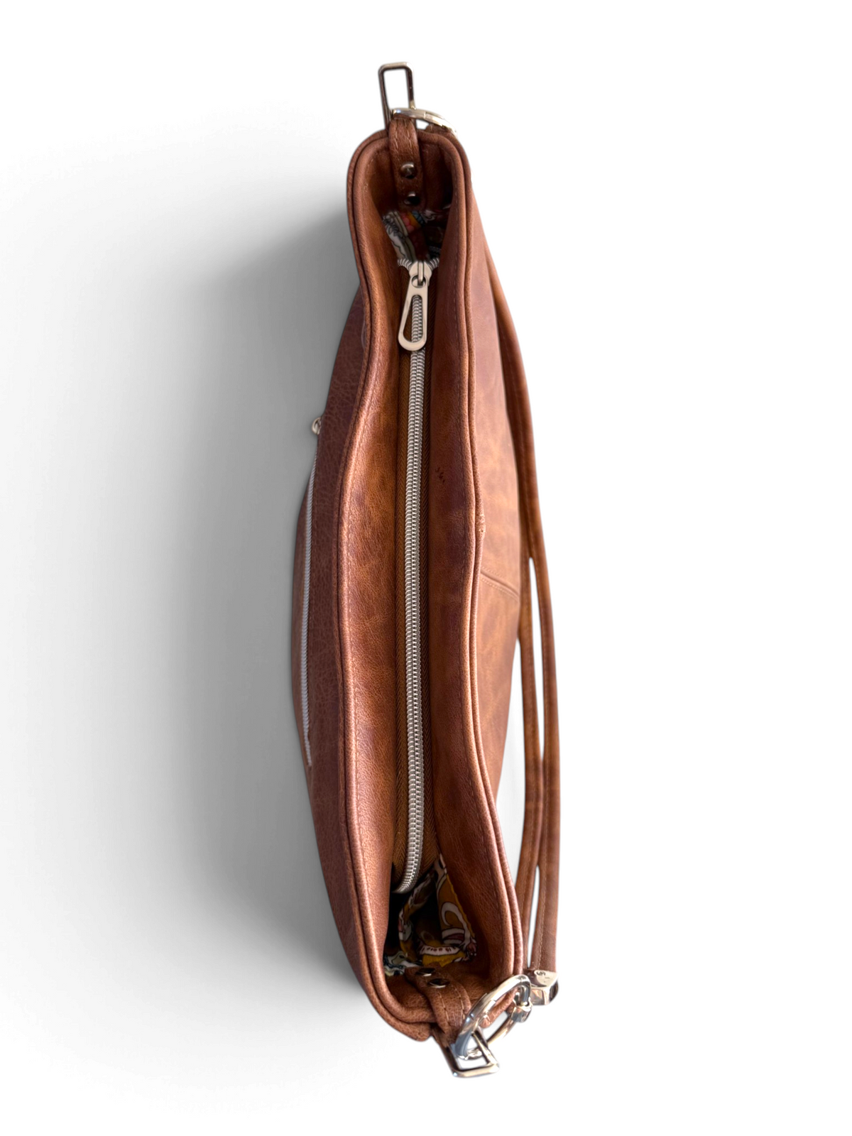 A brown leather bag shown from a top profile view, featuring a silver zipper and hardware, set against a plain white background.