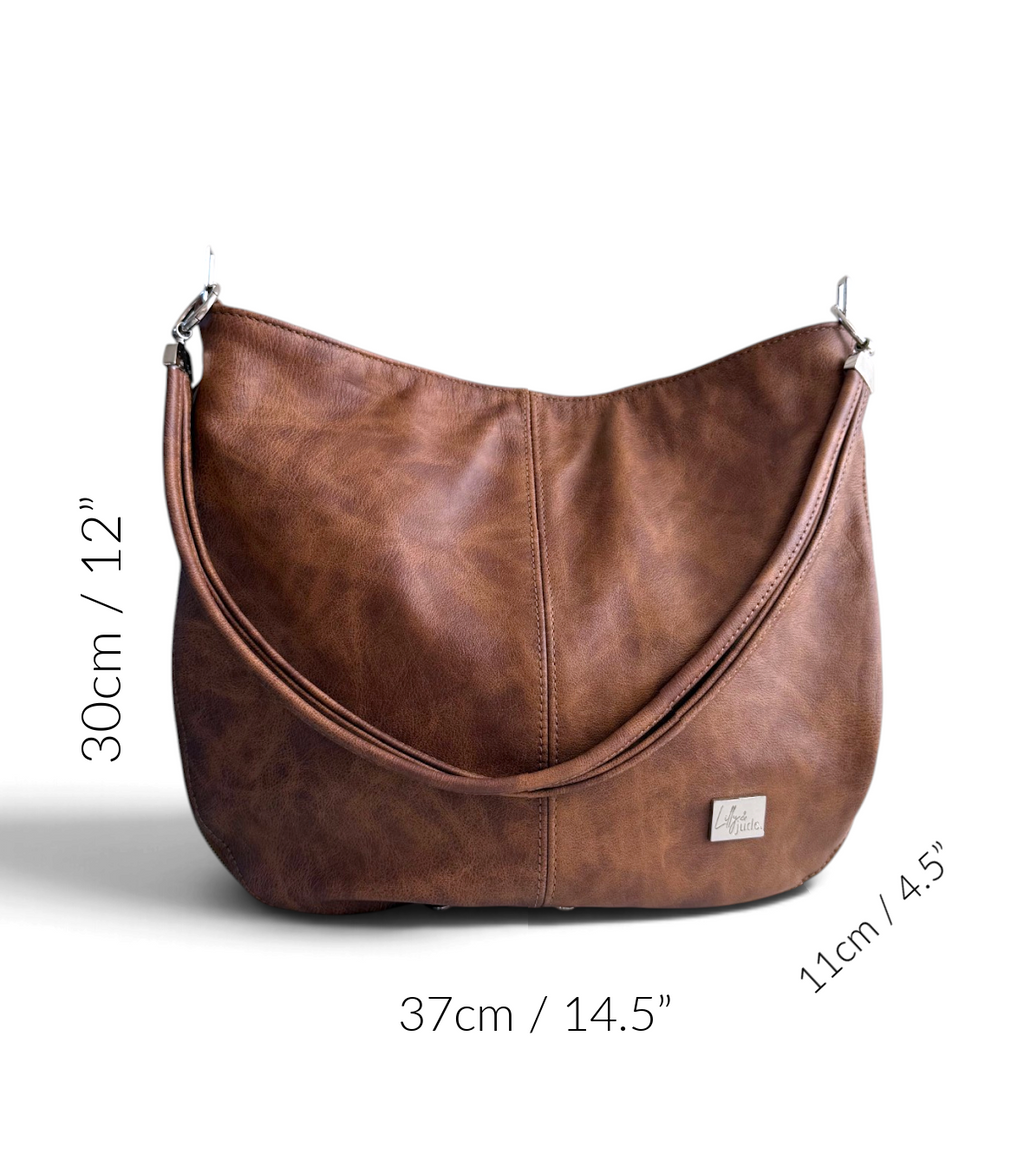 A brown leather hobo shoulder bag with dimension markings showing its measurements of 30cm/12" height, 37cm/14.5" width, and 11cm/4.
