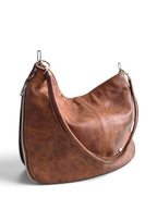 A brown dappled leather, slouchy shoulder bag with silver-tone hardware, shown on a clean white background.