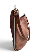 Side view of a brown, rescued leather shoulder bag with a slouchy crescent shape, featuring a silver zipper and a  shoulder strap, shown on a white background.