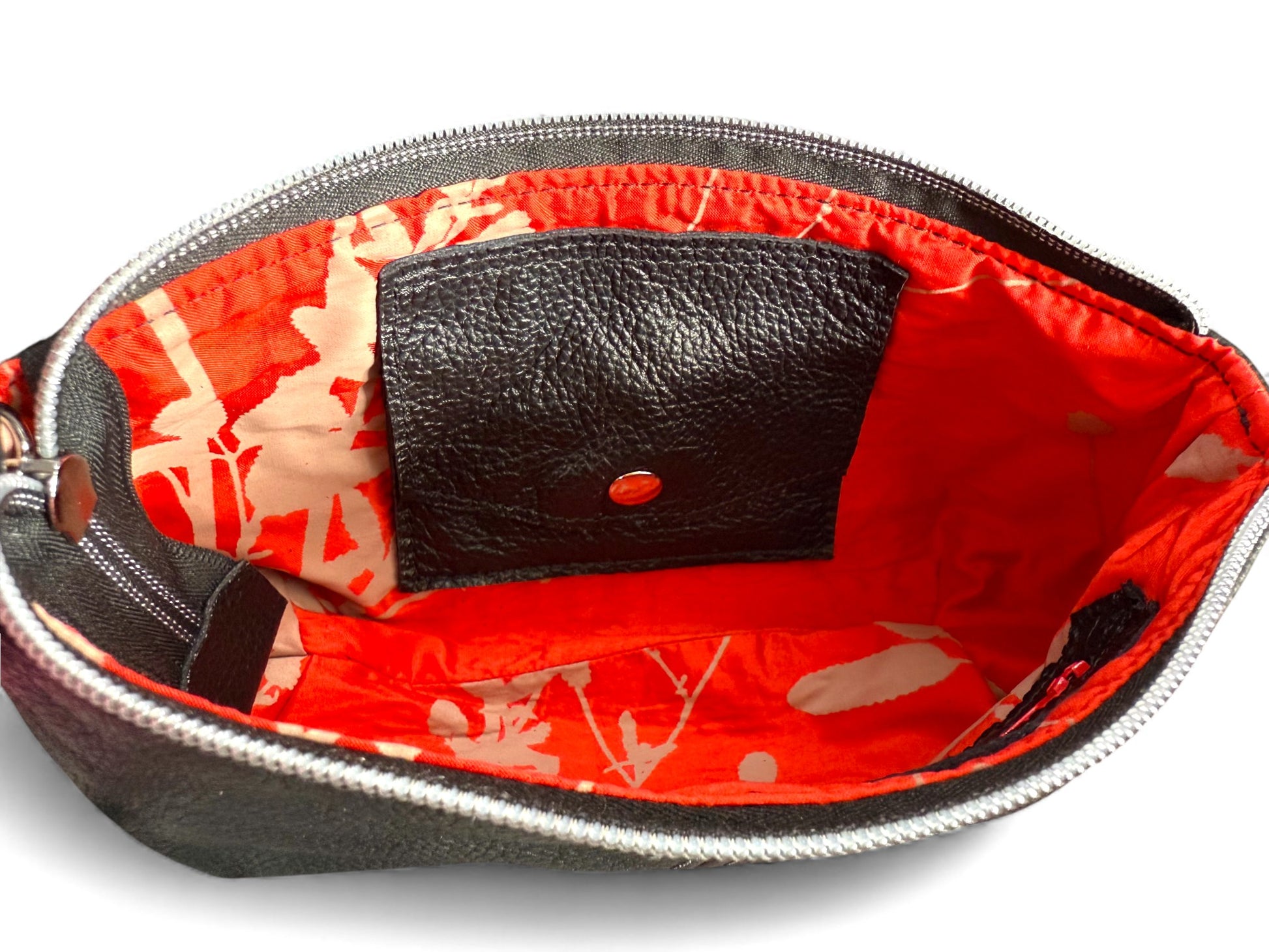View of the open Ella evening bag, with red floral silk interior , highlighting the integrated leather purse