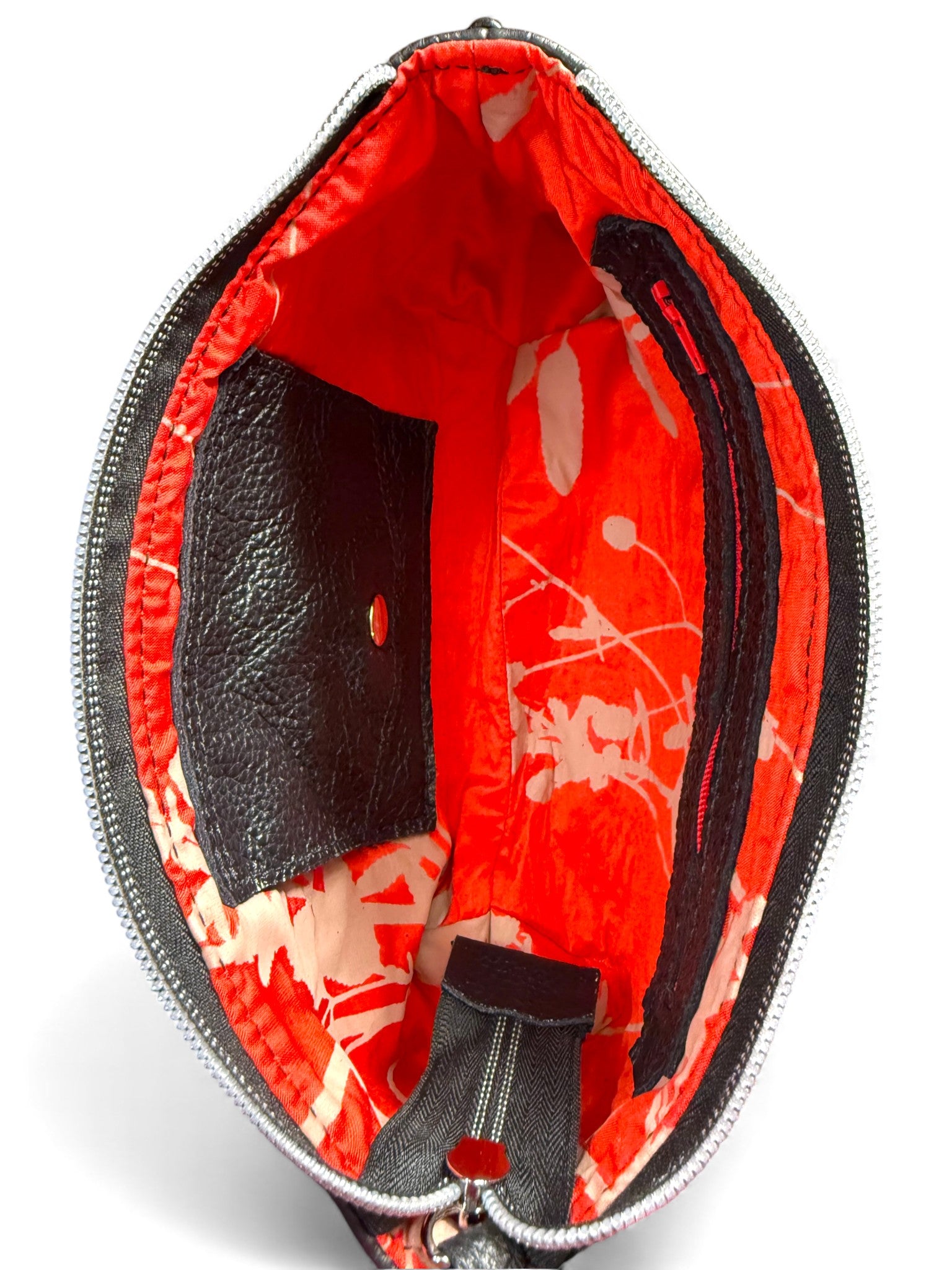 Birds Eye view of the interior of the black Ella wristlet pouch, showing the red silk lining, interior purse and the zipper pocket. Handcrafted using rescued leather