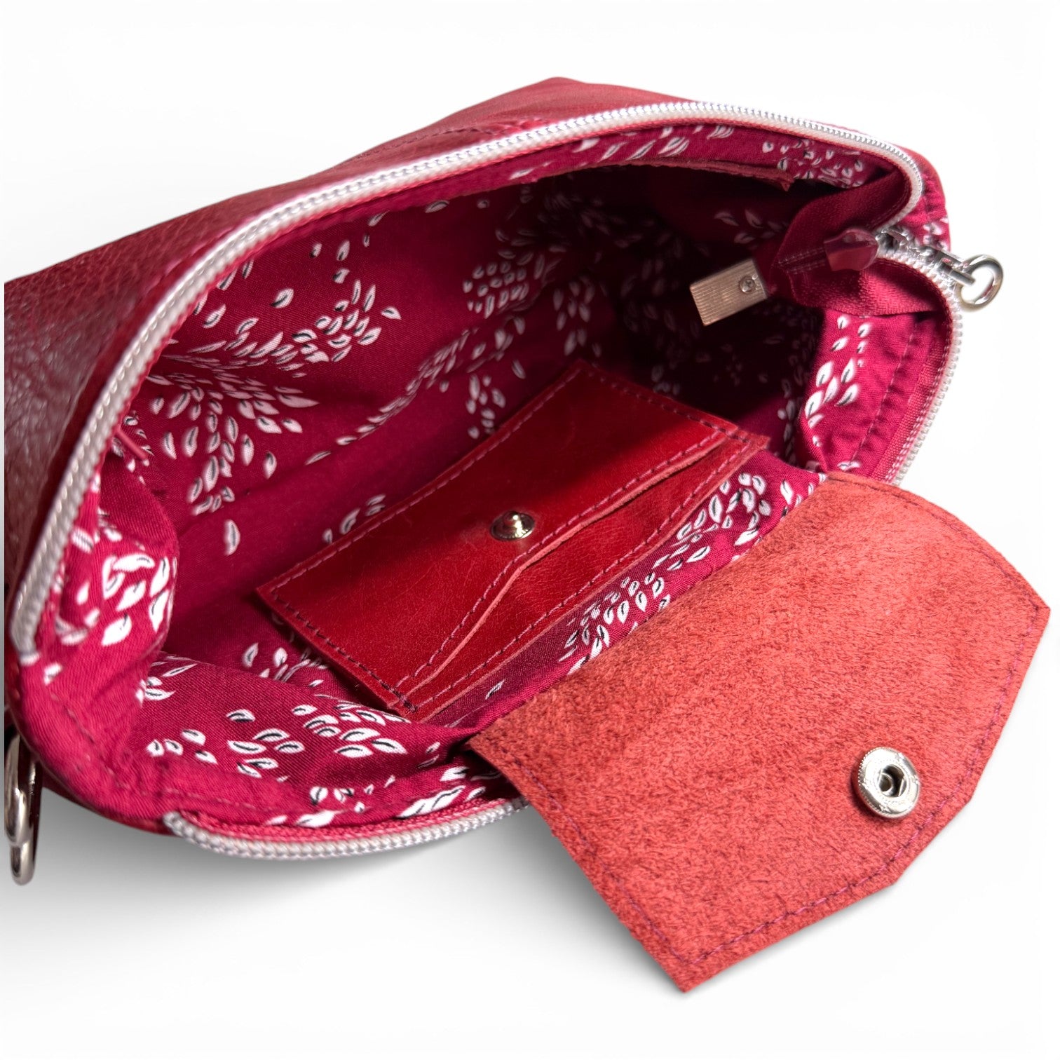 Red patterned pouch with an integrated wallet inside on a white background