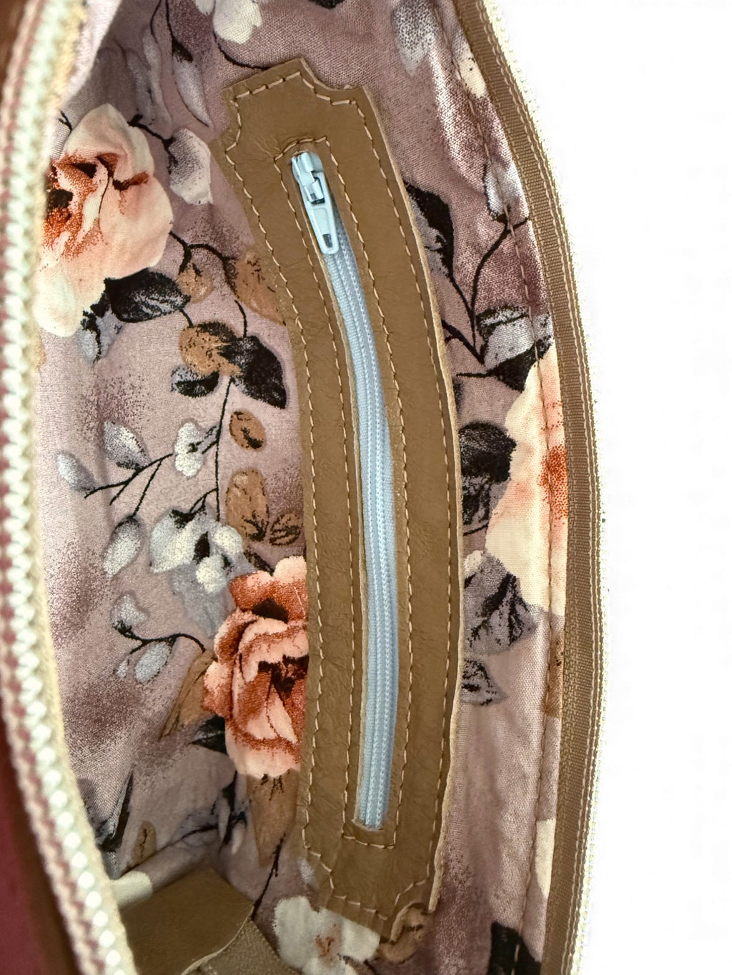 Interior view of the Taupe leather Ella wristlet. The image shows the floral-patterned pouch with a matching zipper
