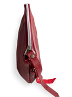 View from above of the Ella in deep red / burgundy leather bag with a silver zipper on a white background. 