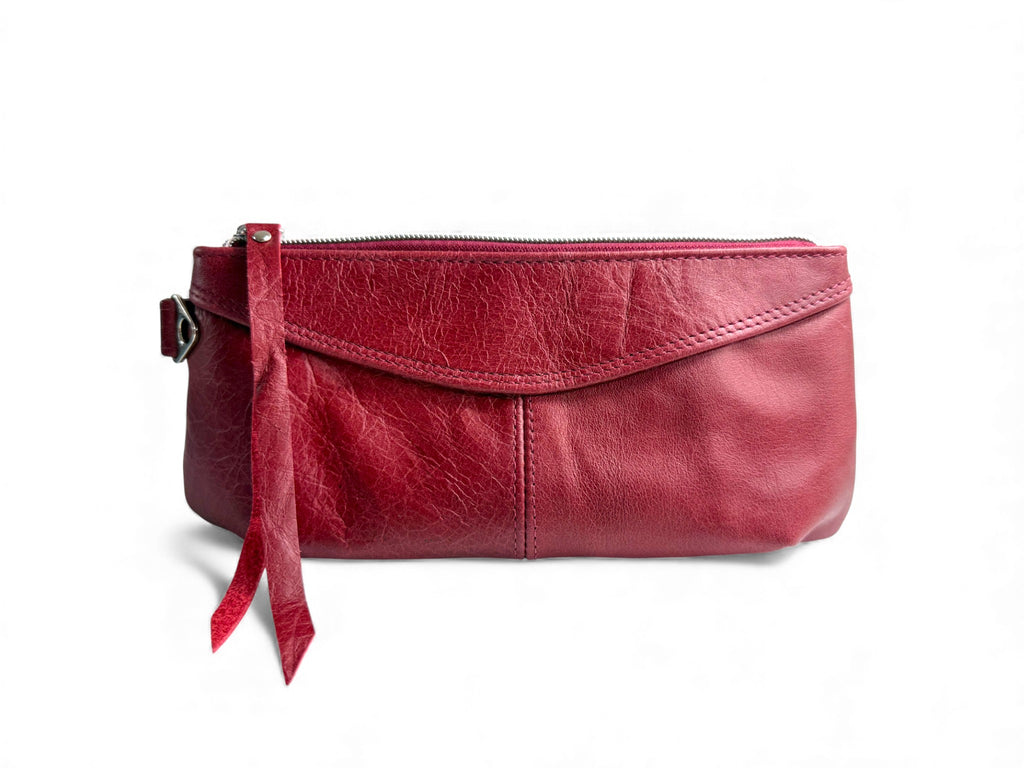 The Ella wrist bag. Red leather clutch bag with a strap on a white background. Handcrafted from rescued leather and exclusive to Lilly & Jude