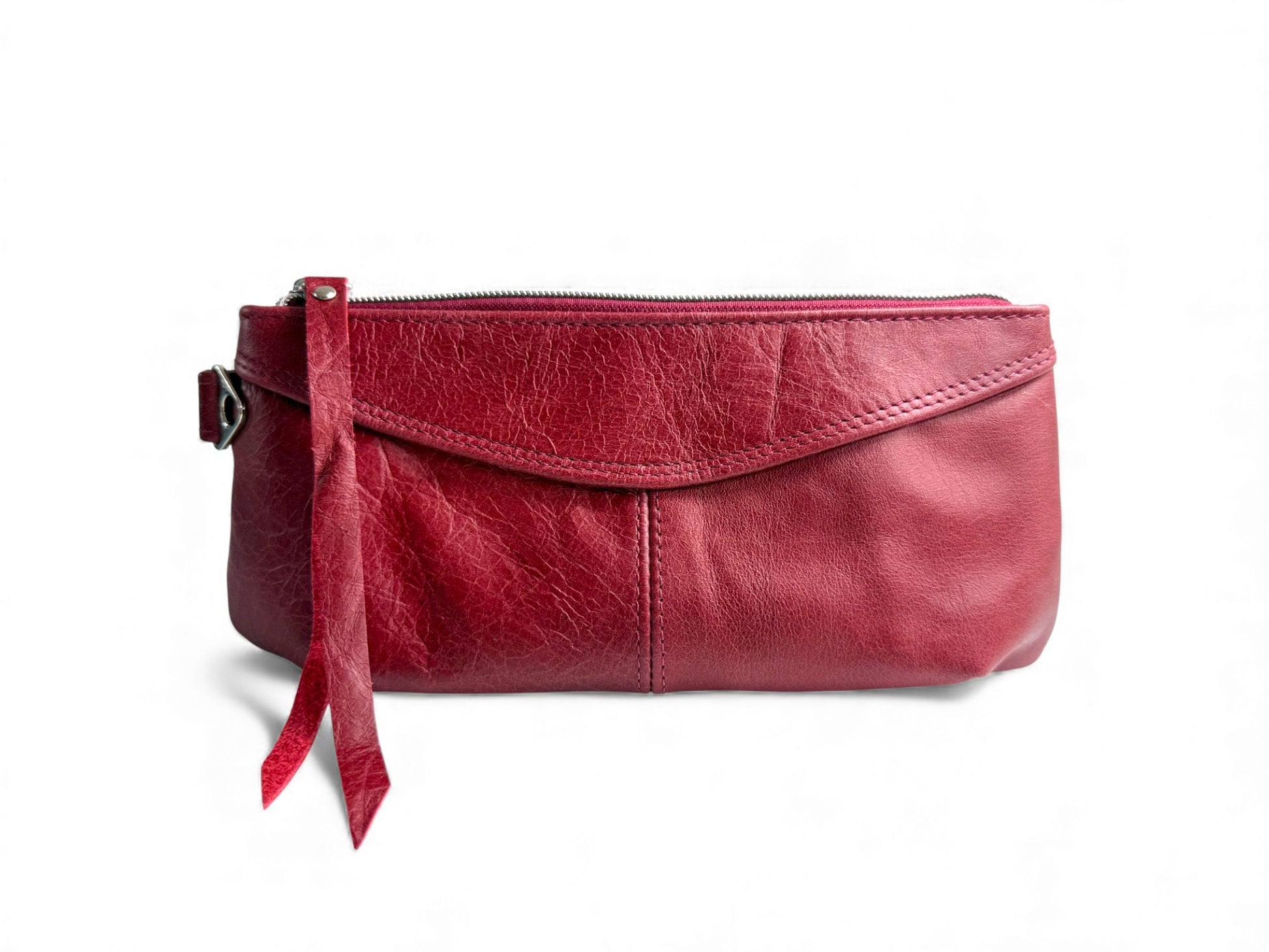 The Ella wrist bag. Red leather clutch bag with a strap on a white background. Handcrafted from rescued leather and exclusive to Lilly & Jude