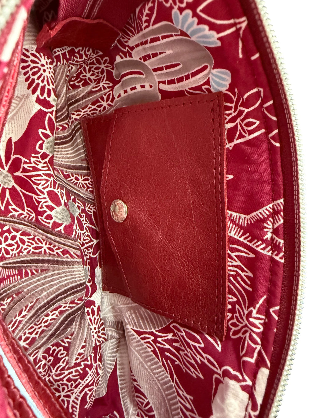 Close-up view of the interior of the Ella clutch bag. It highlights the Lilly & Jude signature integrated purse with silver press stud.