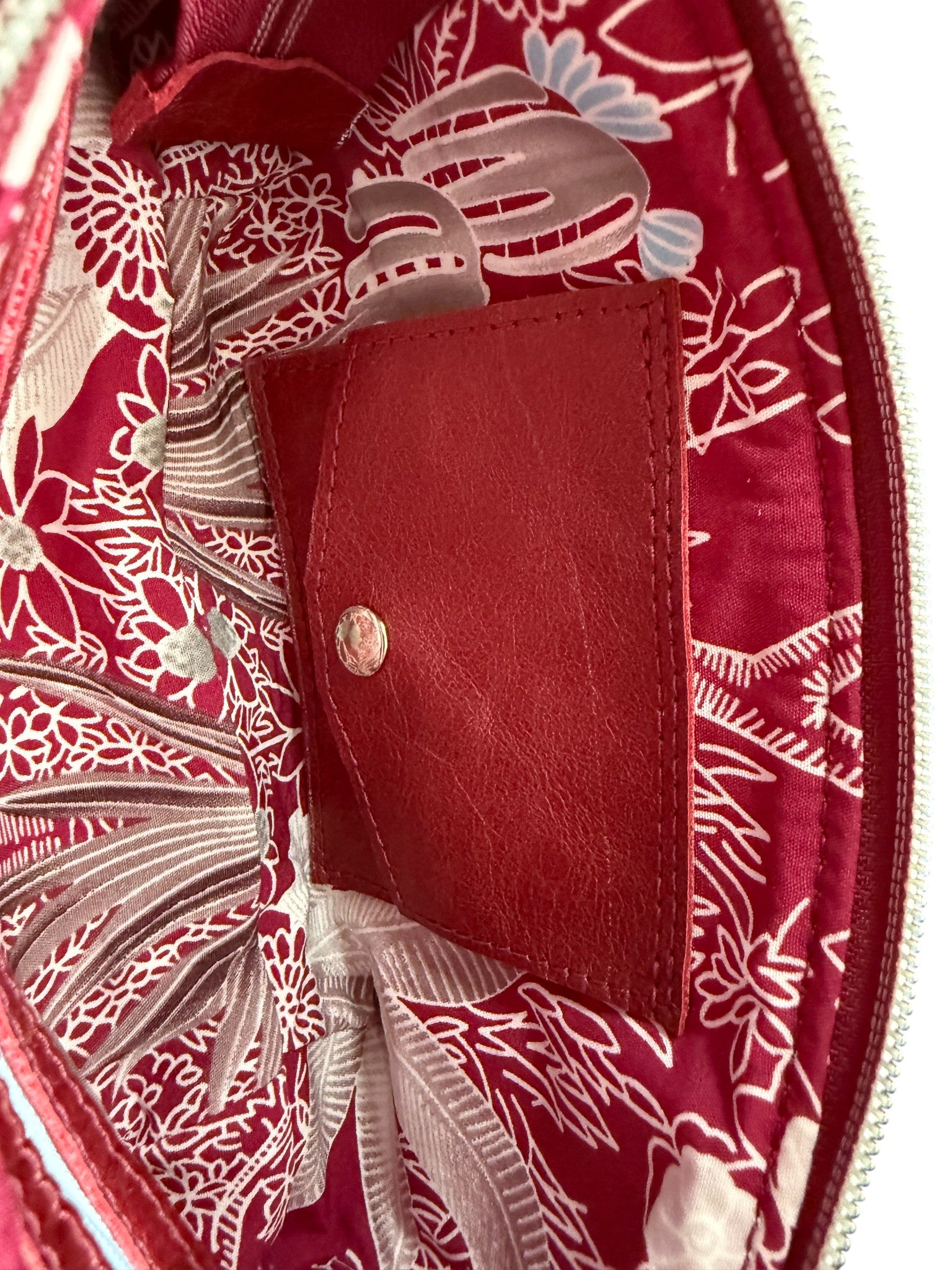 Close-up view of the interior of the Ella clutch bag with integrated purse with silver press stud.