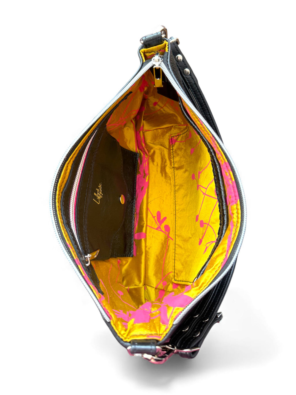 Open handbag with acid gold interior and hot  pink floral patterned silk lining, on a white background