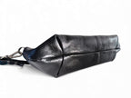 View of the bottom of the Elland Baguette style, black leather bag. The image shows the seams on the bottom of the handbag and the texture of the beautiful rescued leather. Exclusively made in the UK by Lilly & Jude 