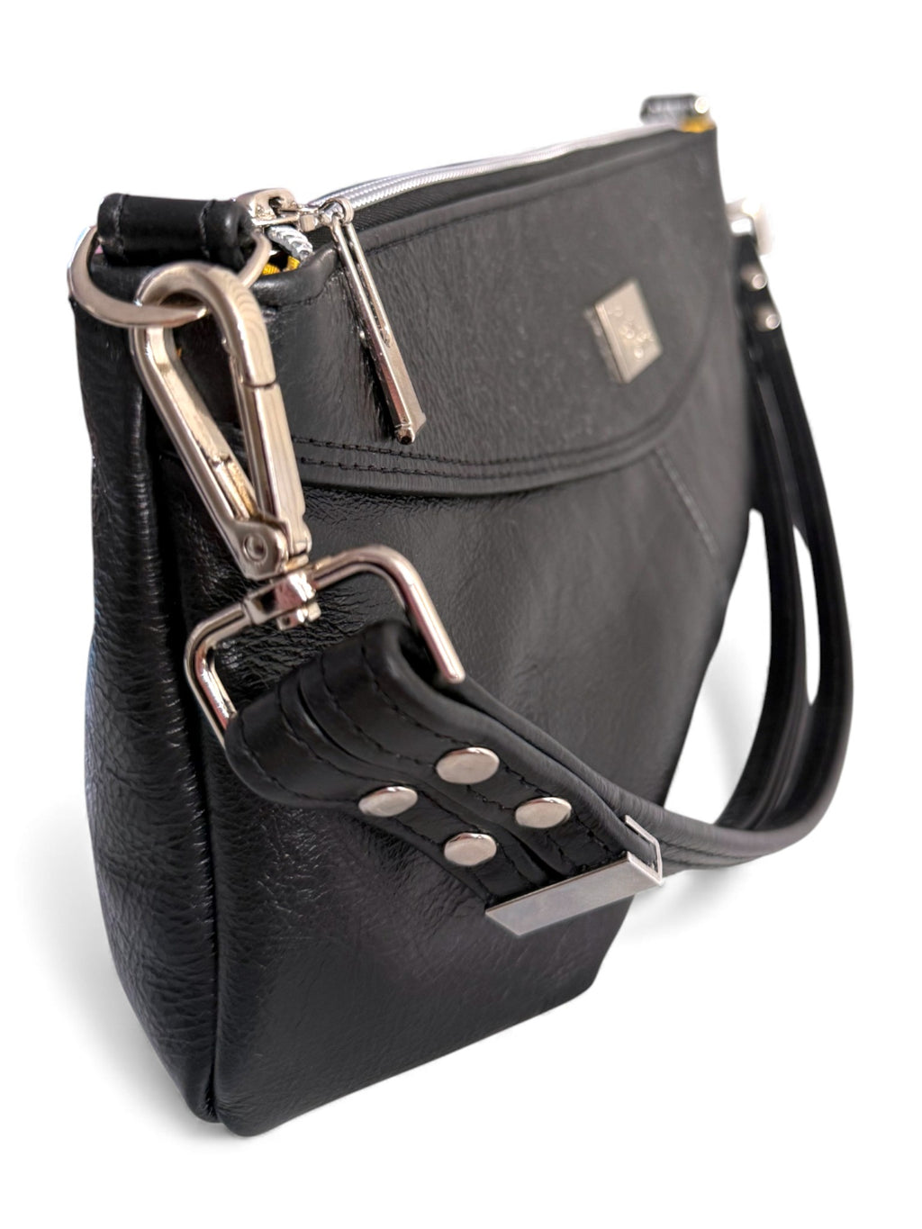 Side view of the Elland handbag, handmade using black, rescued leather. Image shows the detail of th silver hardware on a white background