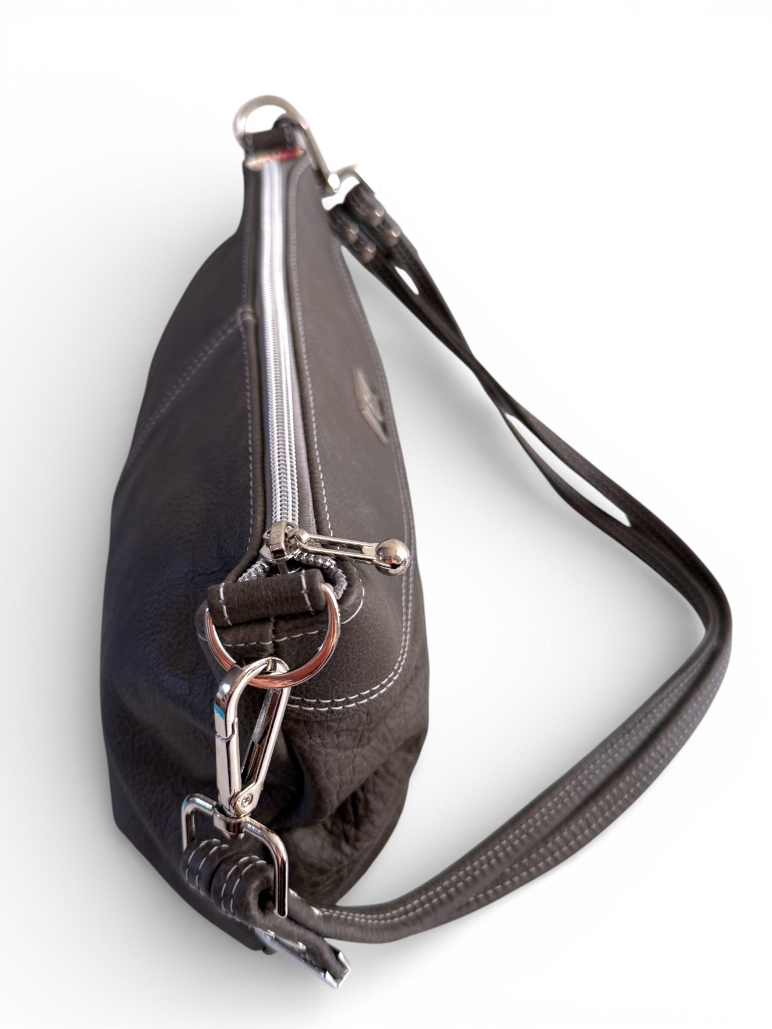 Top view of a charcoal grey leather handbag with silver zippers on a white background