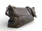 Gray leather handbag with a strap and silver hardware on a white background