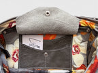 Close-up of a floral-patterned bag interior with a grey leather integrated purse and visible brand label.