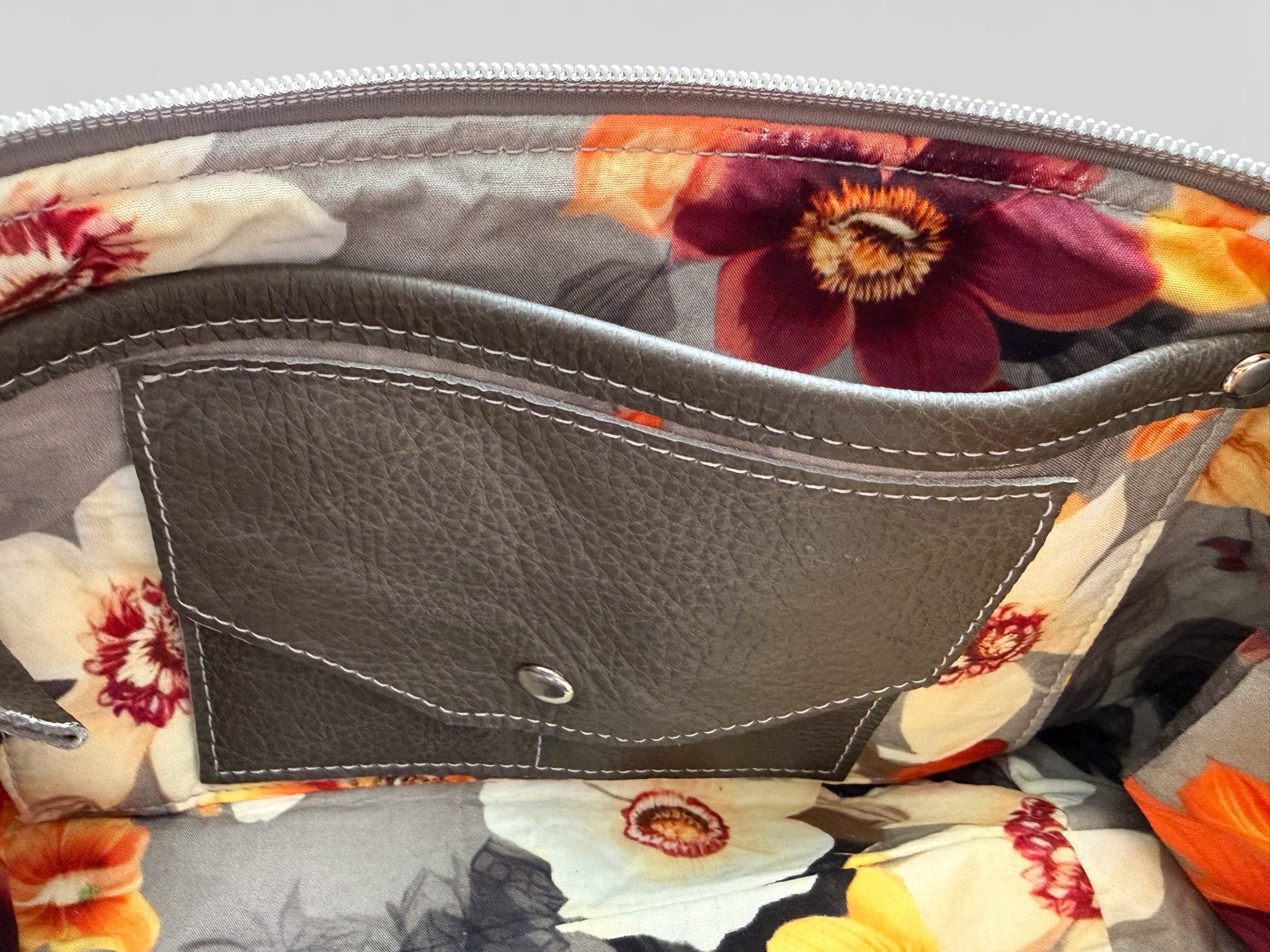 Interior view of the Elland bag, showing Floral-patterned lining with a grey leather integrated purse