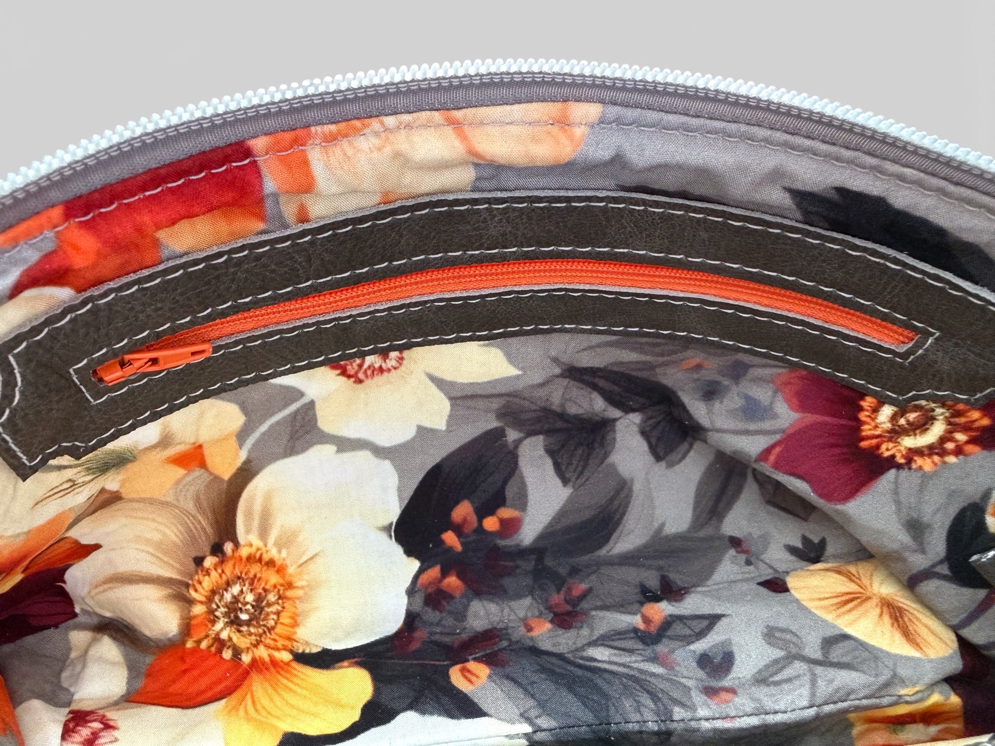 Interior view of the floral-patterned lining with an orange zipper 