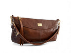 Brown leather handbag with gold accents on a white background