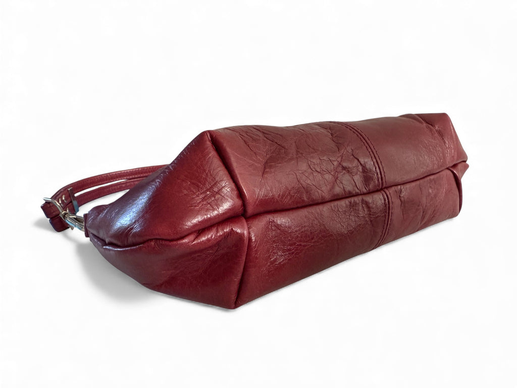 View of the bottom of the Elland East/West, red leather handbag on a white background