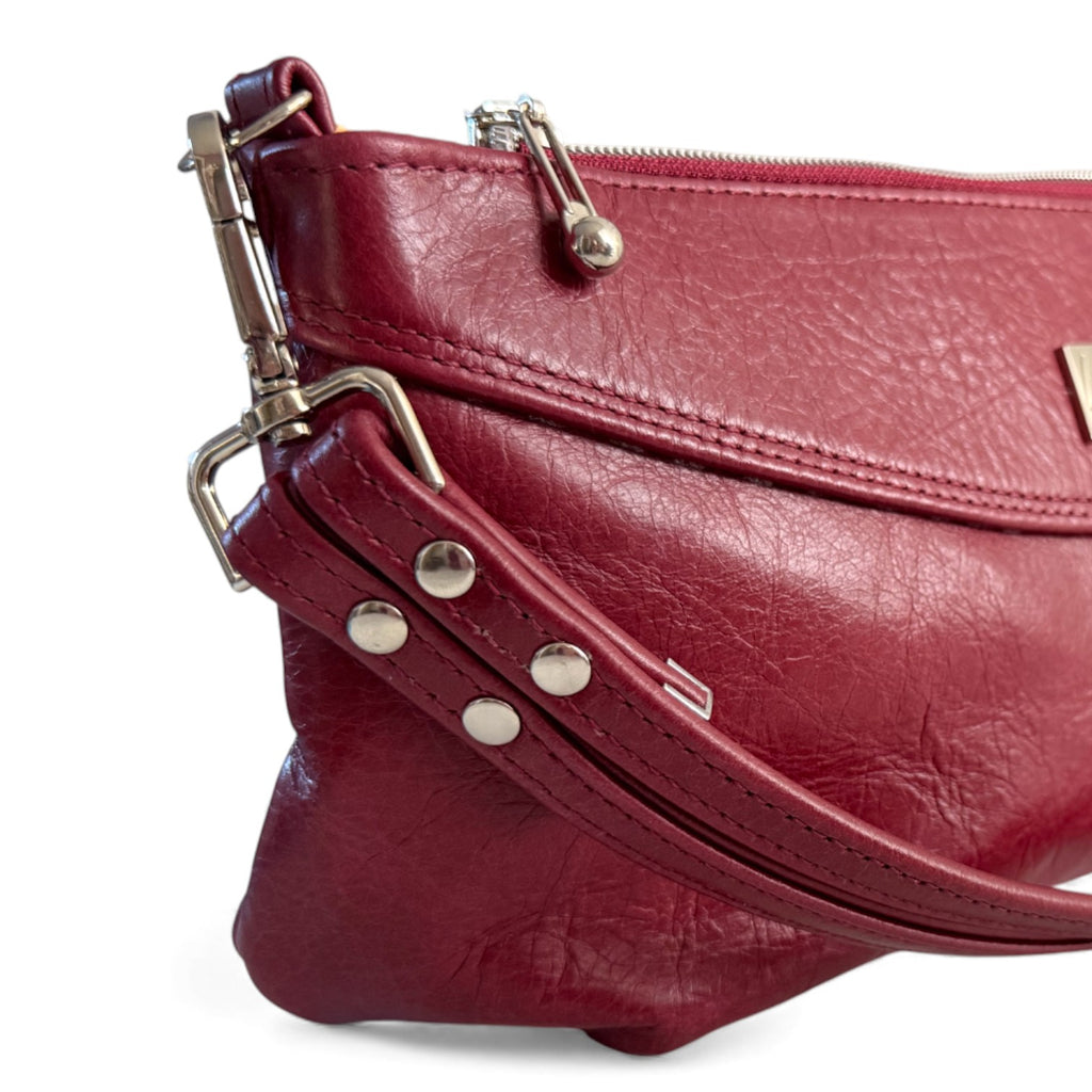 Red leather handbag with silver  hardware on a white background