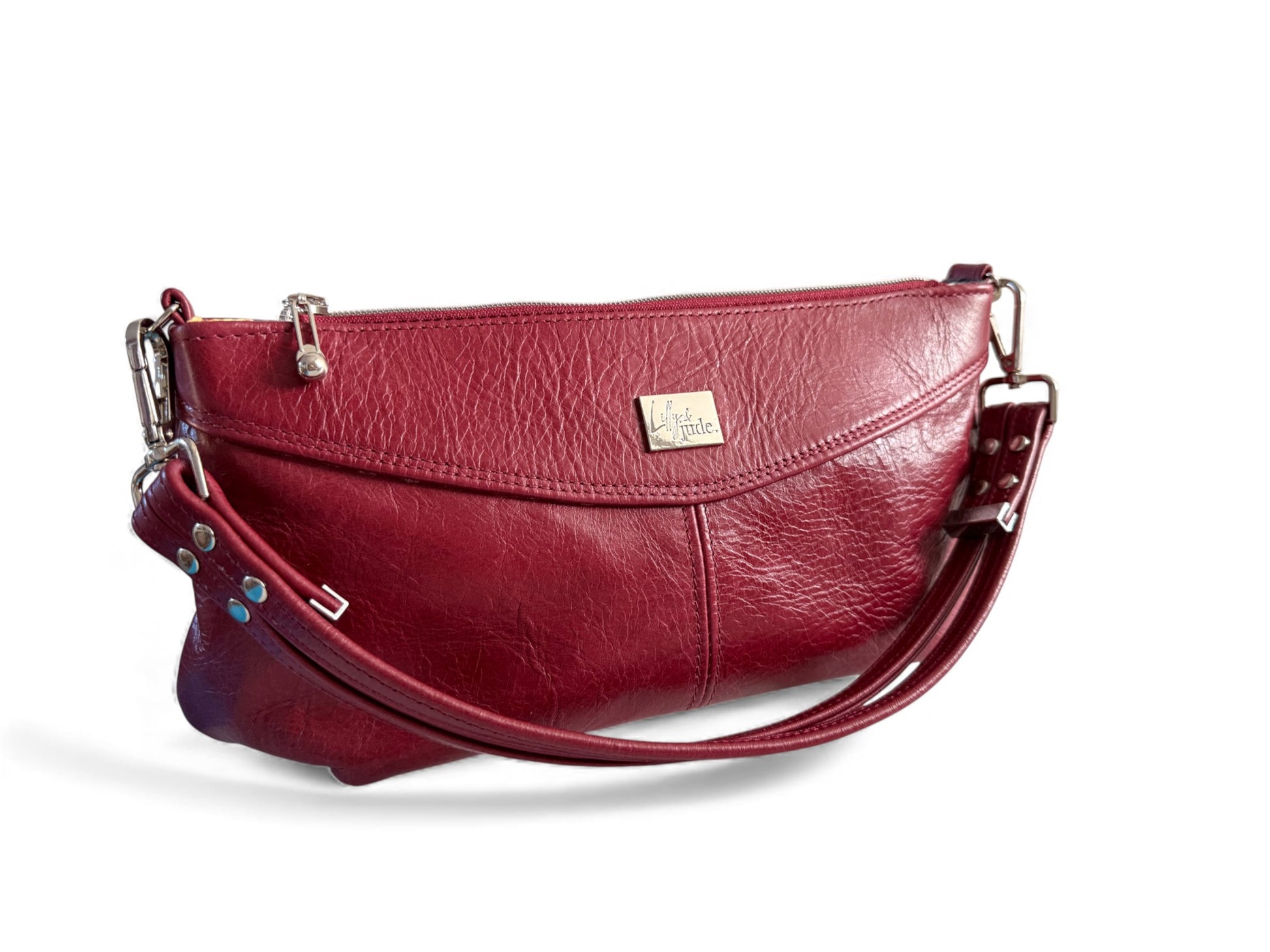 Handcrafted, red leather handbag with a silver Lilly & Jude logo, on a white background