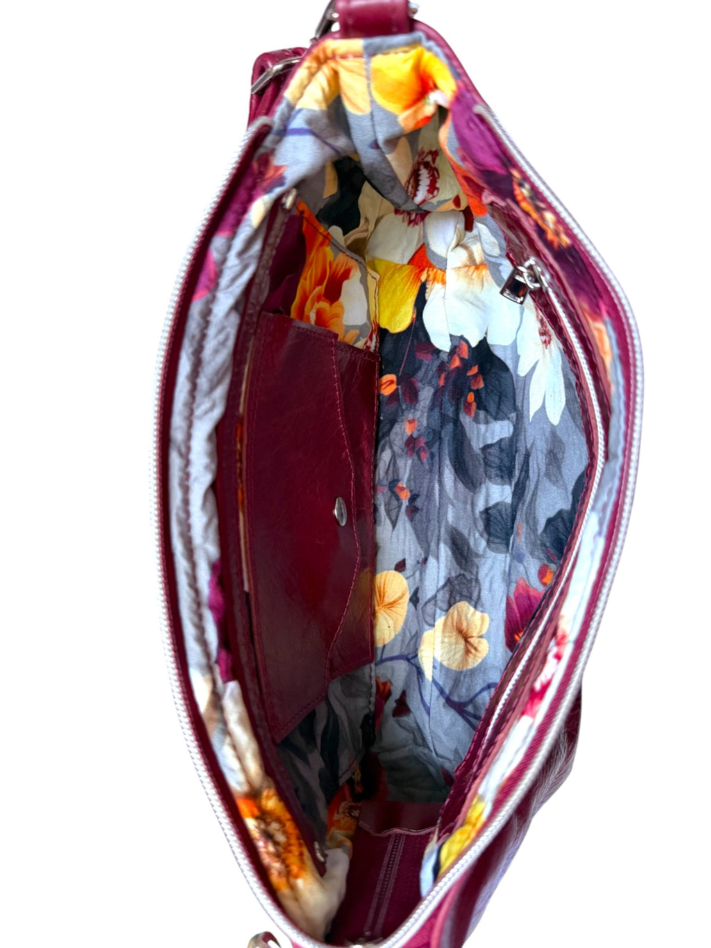 Birds Eye view of the interior of the Elland Bag by Lilly & Jude. The interior is lined with grey floral lining fabric and has a zipper pocket, slip pocket and integrated purse