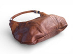 Brown leather handbag, lying on a white background, showing the bottom seam of the base of the bag