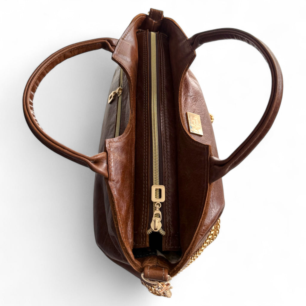 Brown leather handbag with gold zipper on a white background