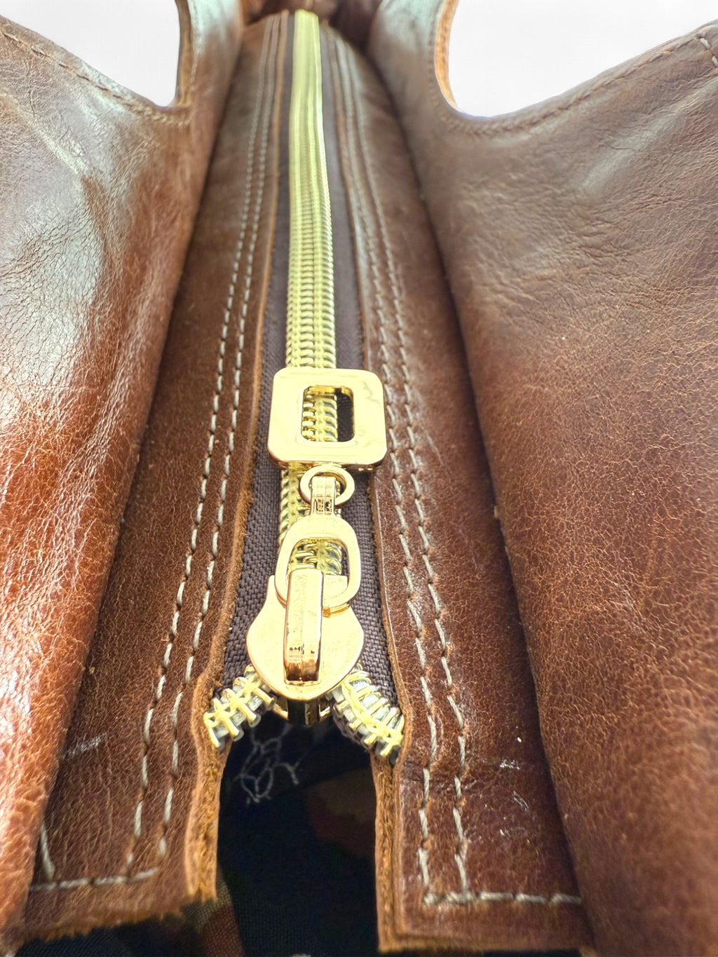 Close-up of the gold zipper on the chocolate  brown leather Flossy Bag. An exclusive, one-off bag by Lilly & Jude