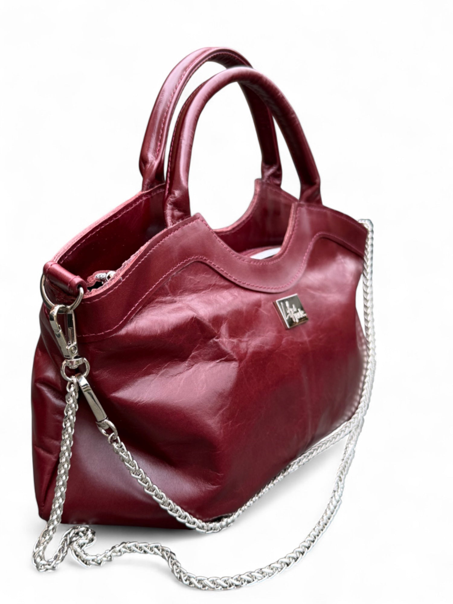 Handcrafted from rescued leather, the image shows the bag from the front/side quarter and highlights the soft, slouchy body of the leather