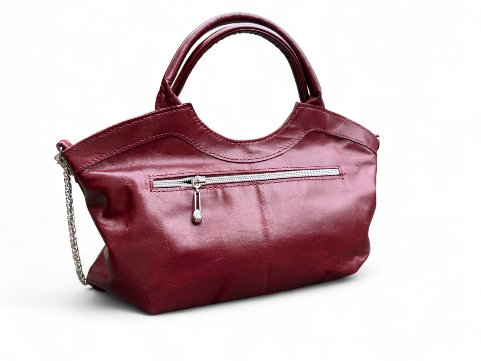 Maroon coloured leather handbag, which was handcrafted in the UK. The image shows the back view of the bag