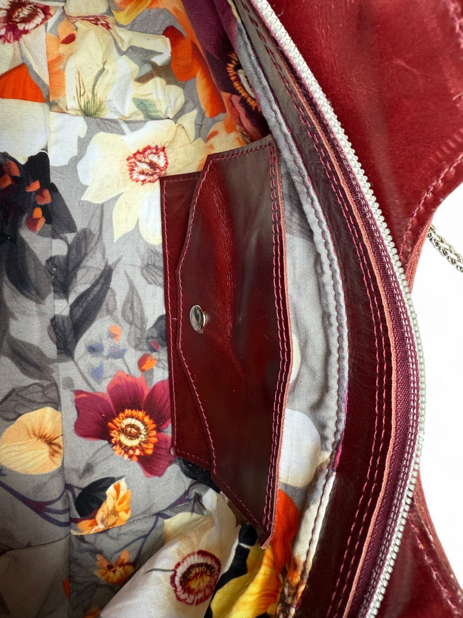 View of the bag from above, showing the floral patterned lining and the signature, integrated leather purse, which holds 2 cards, cash and coins and saves you having to carry a wallet