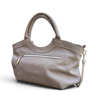 A grey leather handbag with dual top handles, a curved top edge, a zippered pocket, and a silver-tone chain strap, shown on a white background.