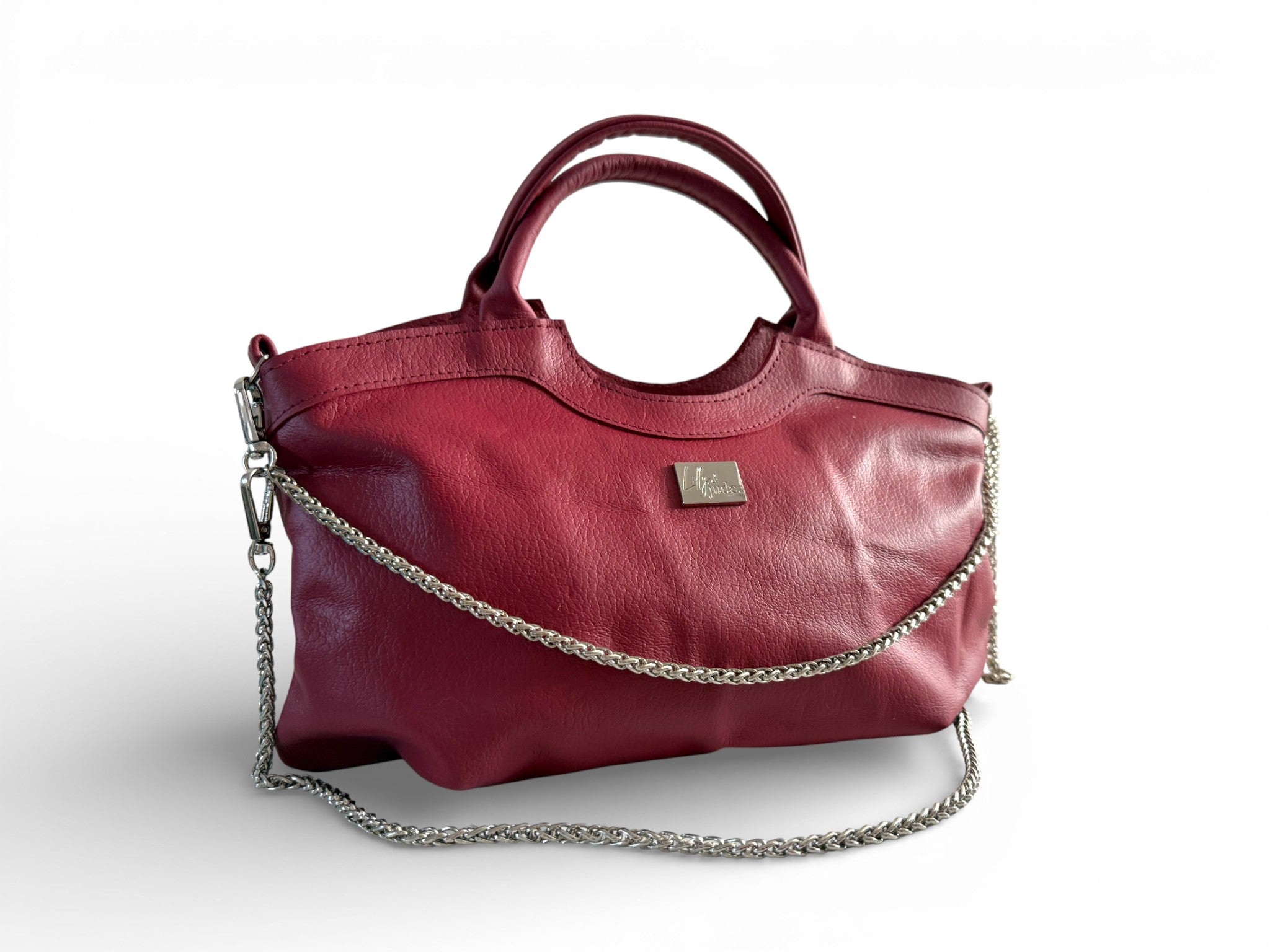 Red handbag with a chain detail and silver Lilly & Jude logo badge, sitting on a white background