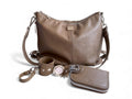 Taupe leather handbag with matching wallet and keychain on a white background