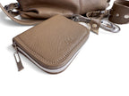 Taupe brown leather wallet with zipper and matching accessories on a white background