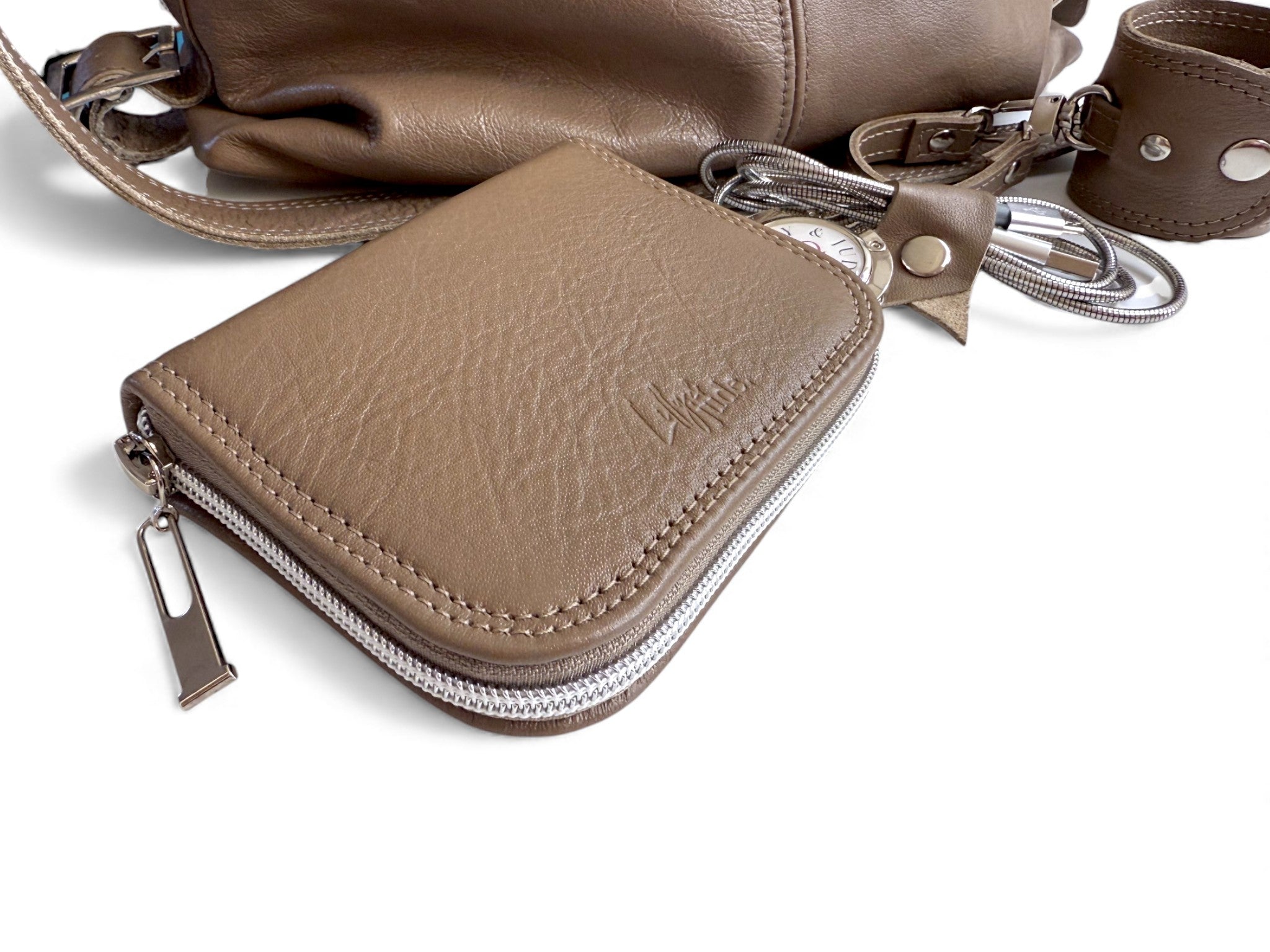 Taupe brown leather wallet with zipper and matching accessories on a white background