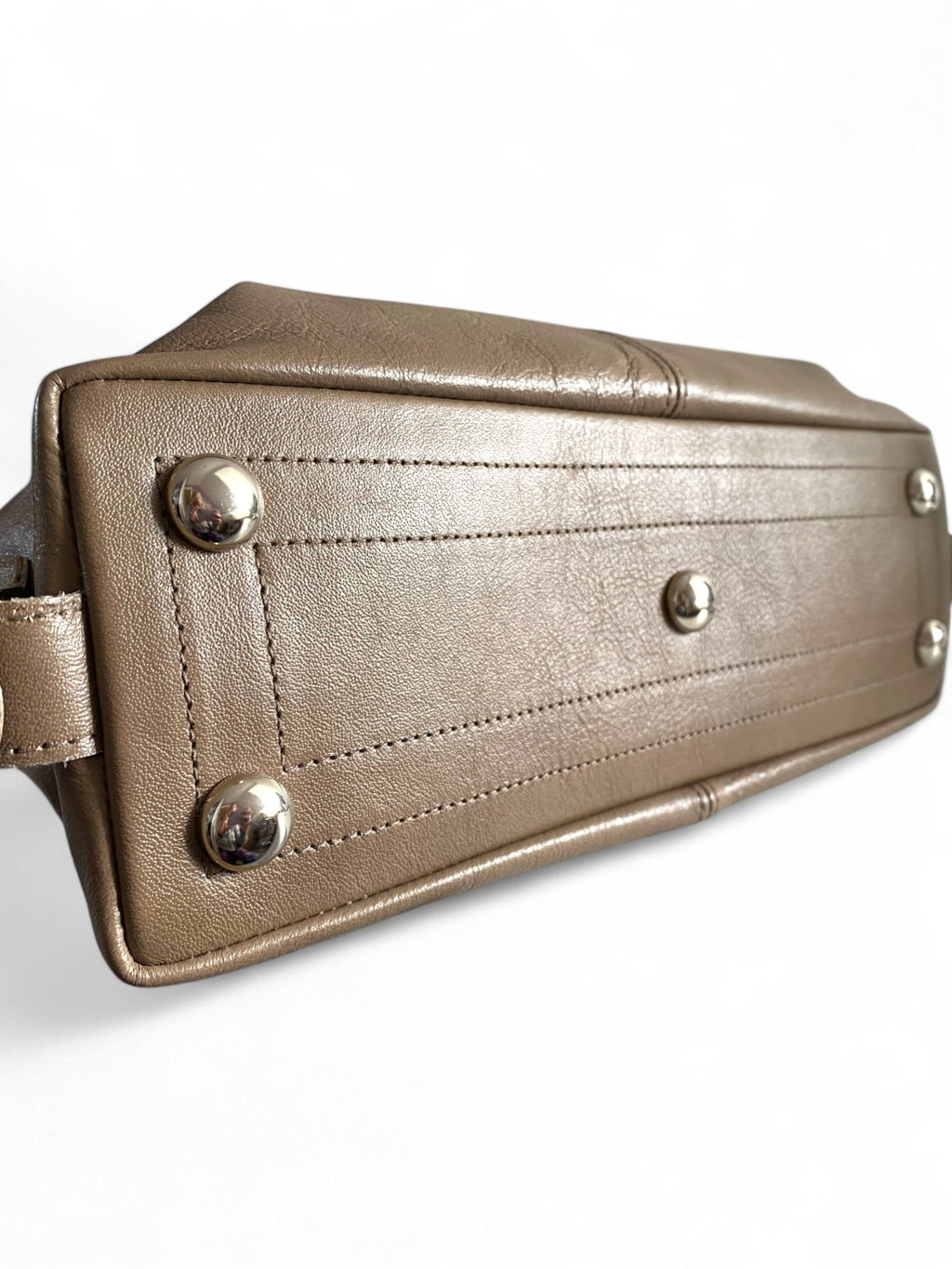 Close-up of a taupe leather bag with silver studs on a white background.