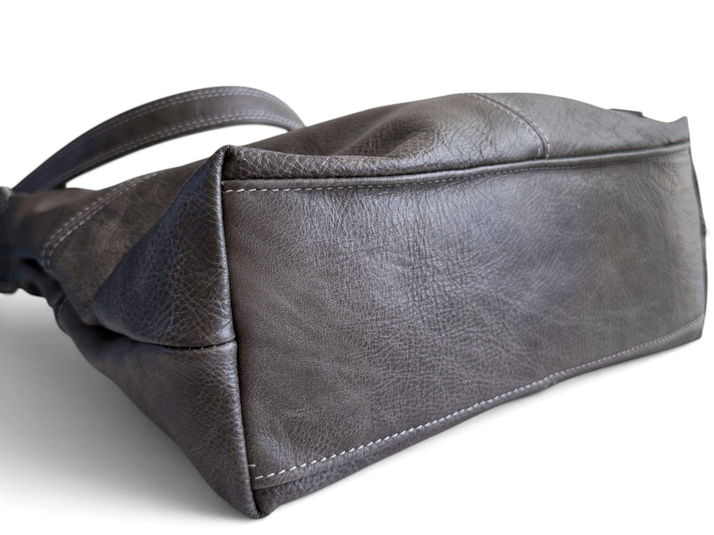 A dark grey textured leather handbag lying down, showing the bottom, on a white background.