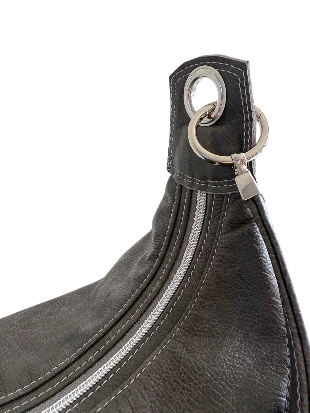 Close-up of a dark grey leather shoulder bag featuring a silver-tone metal ring and strap attachment on a white background.