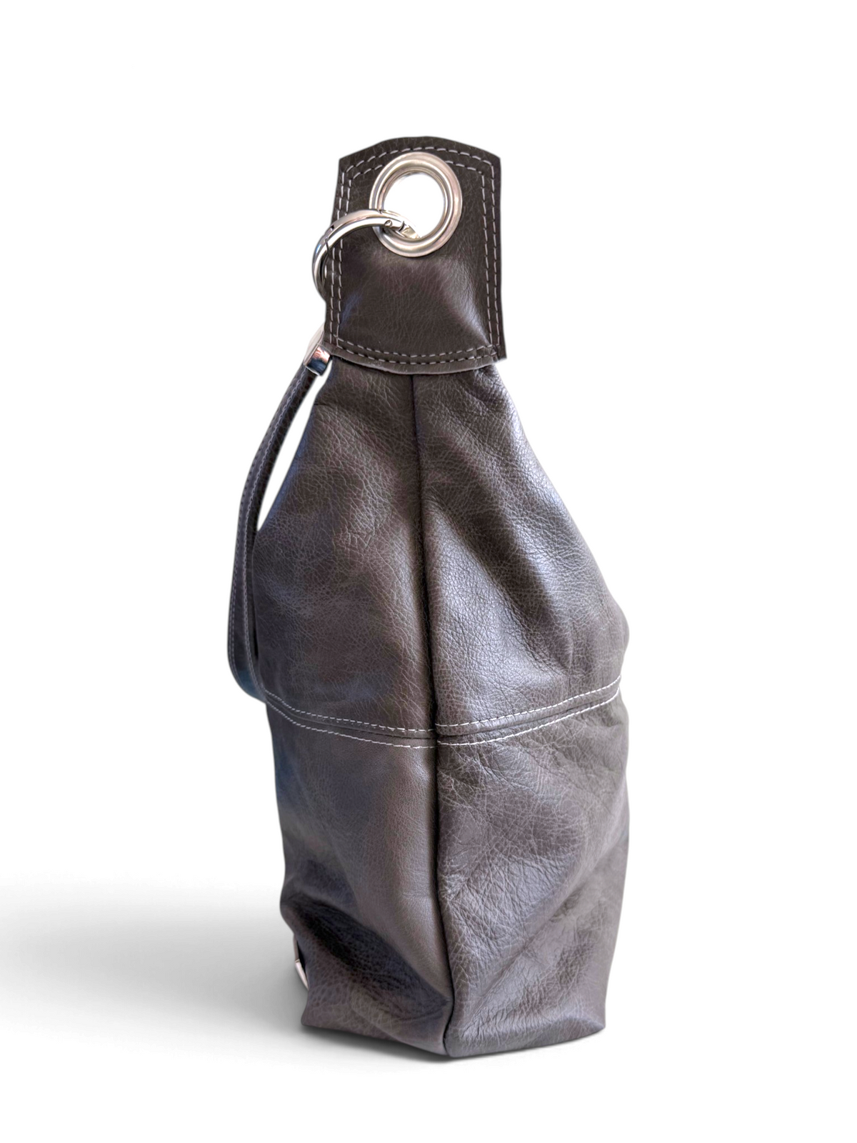 A dark grey leather shoulder bag with a slouchy silhouette, featuring a silver-tone metal grommet and ring detail on the top strap, set against a plain white background.