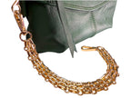 Gold chain strap on a green handbag