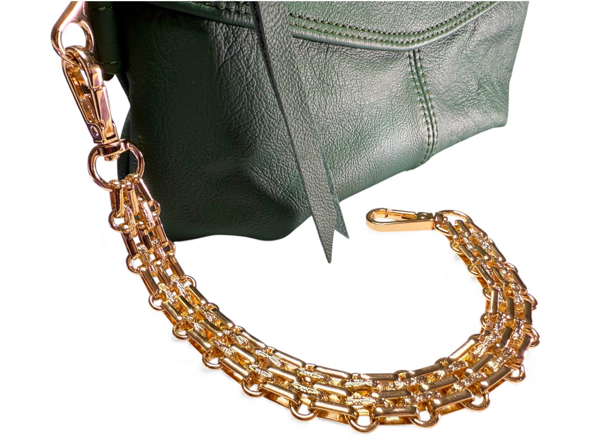 Gold chain strap on a green handbag