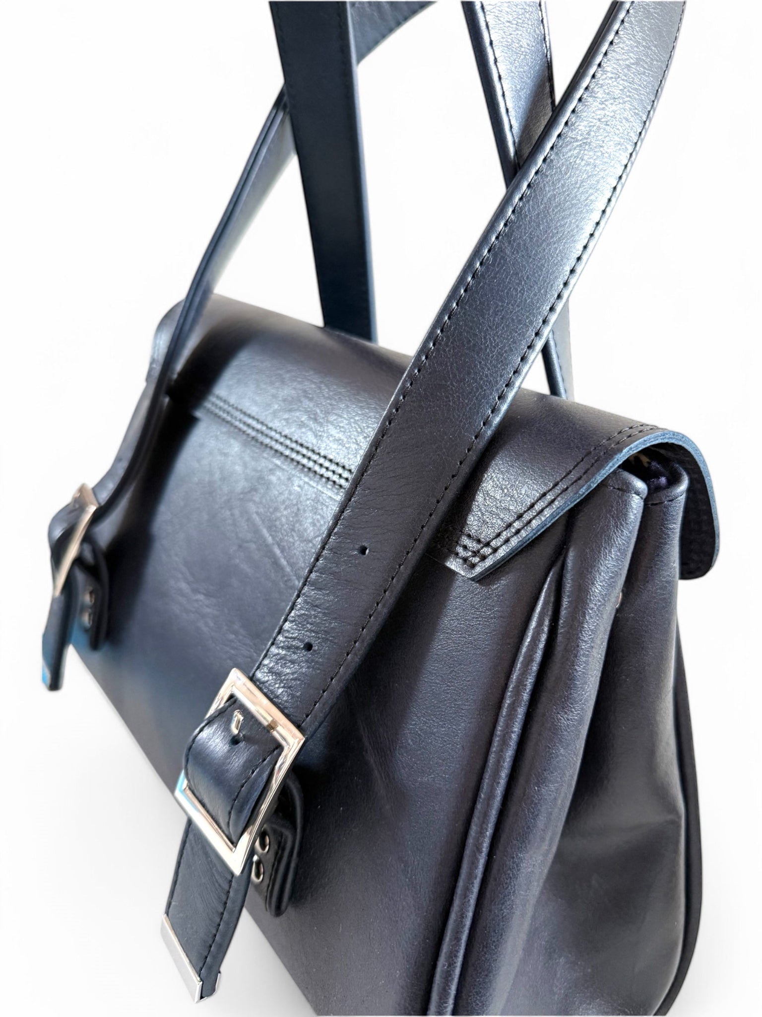 Black leather satchel with strap on a white background