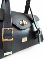 Navy leather handbag with silver buckles and turn clasp on a white background