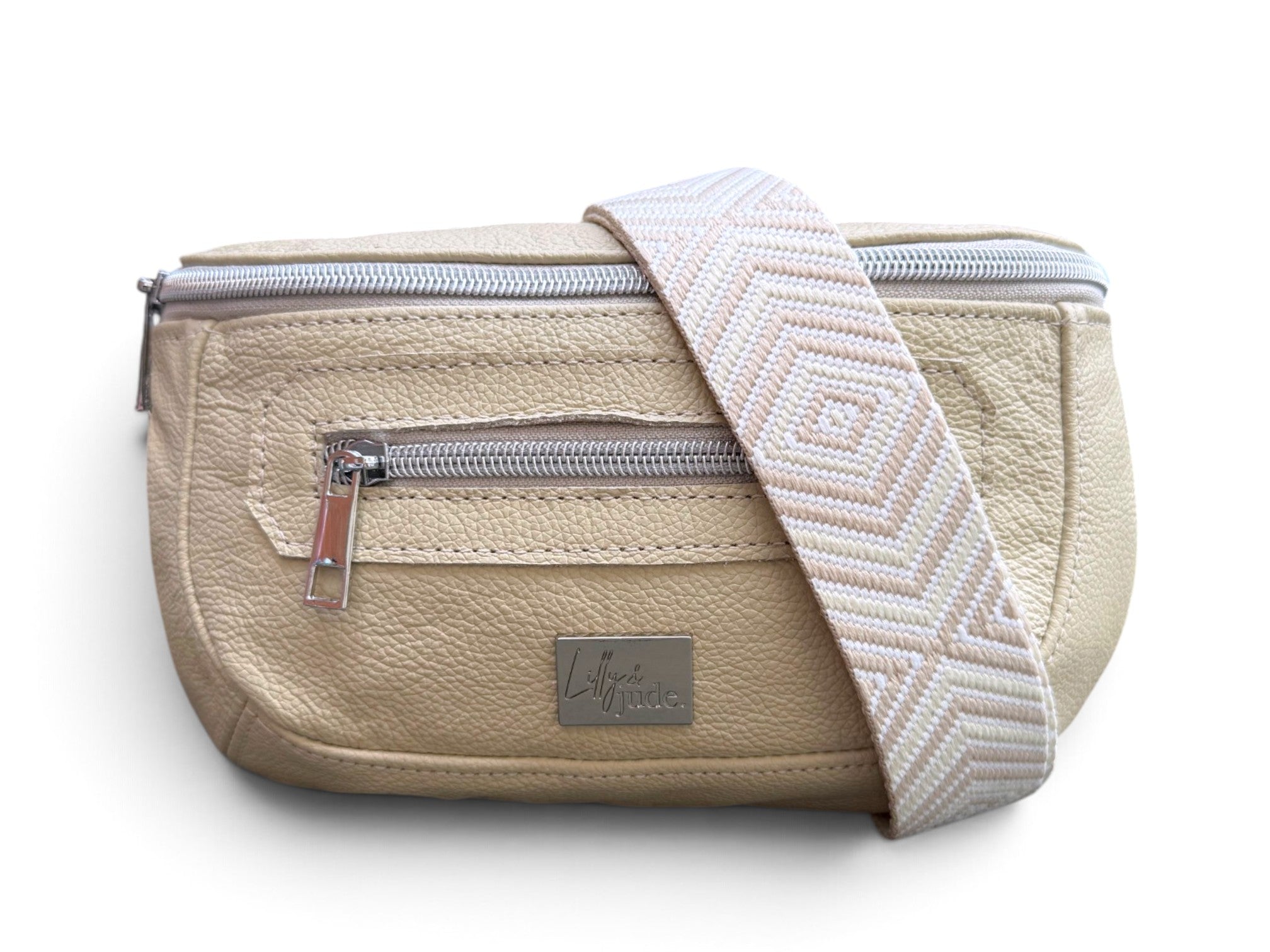 A cream coloured leather bum bag with a patterned cream and beige woven shoulder strap, featuring silver zippers and a brand label on a white background.