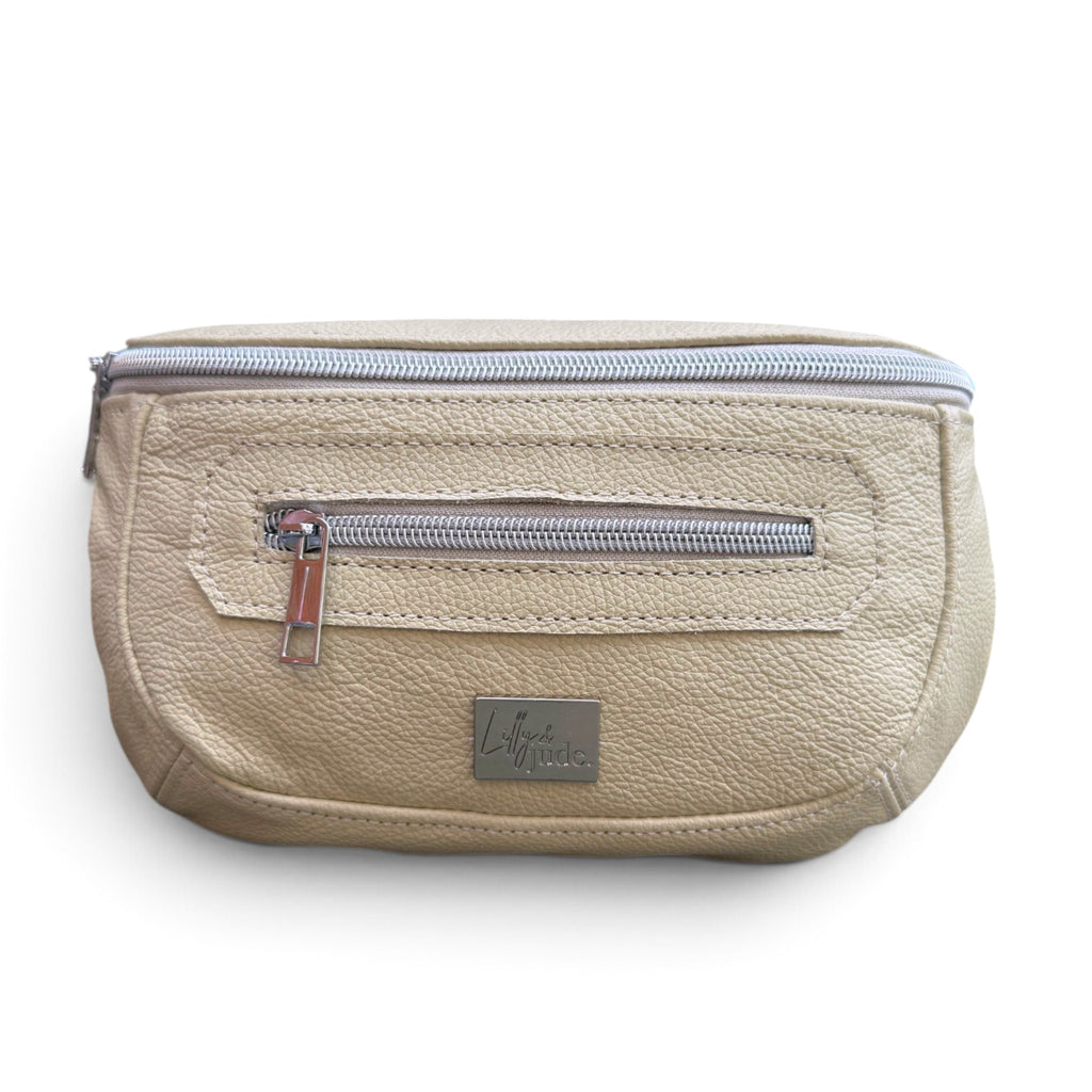 A cream, textured leather waist bag with a silver zipper and a small silver brand plaque on the front, shown against a plain white background.