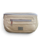 A cream, textured leather waist bag with a silver zipper and a small silver brand plaque on the front, shown against a plain white background.